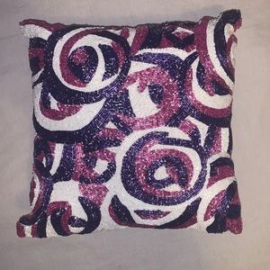 pink and purple beaded pillow with swirls